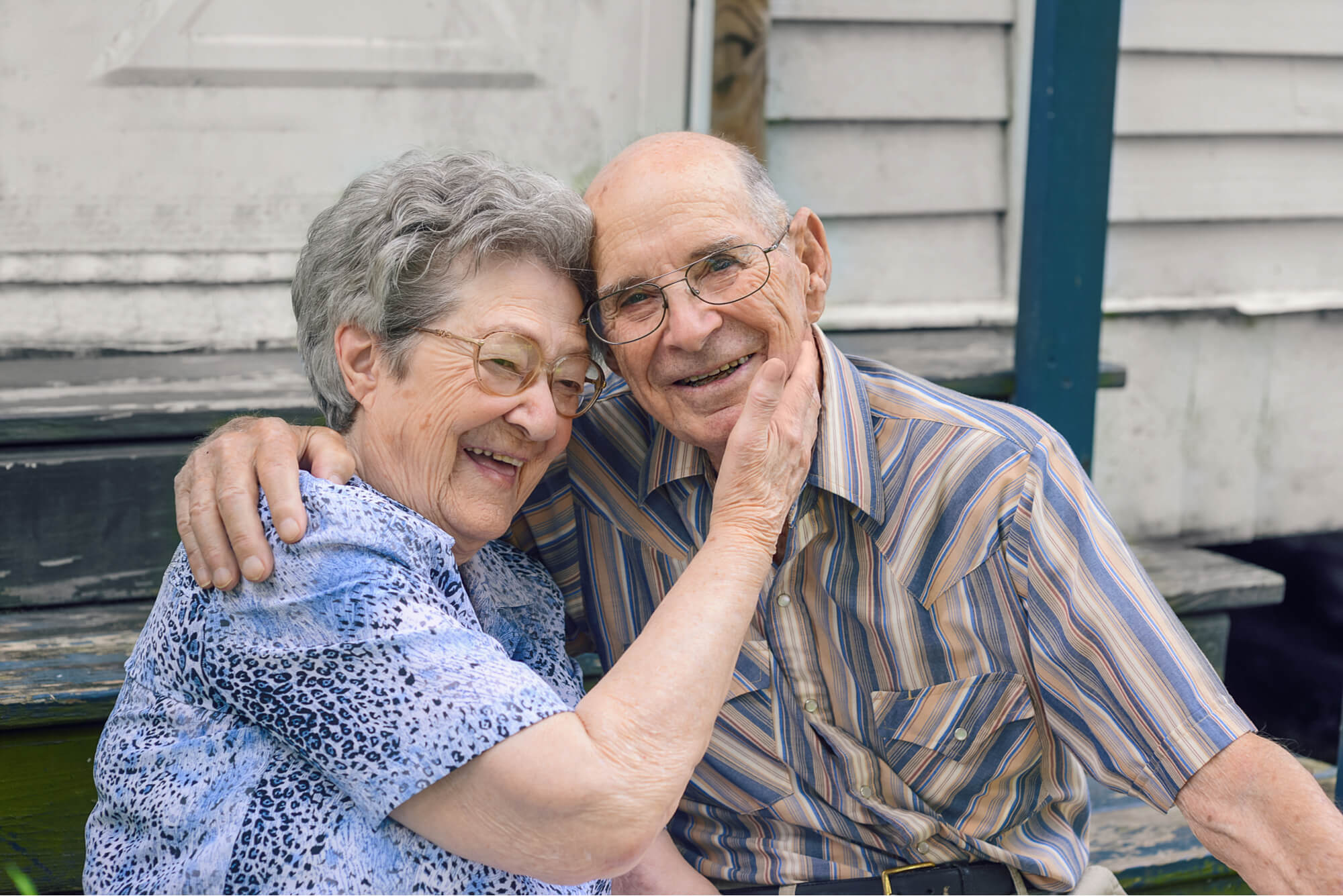 Buffalo – Seniors on a porch (1) Louisiana seniors sitting outside on a porch together, smiling to show they're happy with their Louisiana Medicare Advantage plan benefits